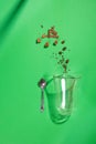 Cappuccino glass cup with sugar and coffee beans on green background with deep shadows, flat lay Royalty Free Stock Photo