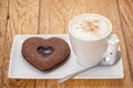 Cappuccino with a heart shaped cookie biscuit