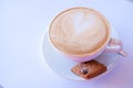 Cappuccino or latte coffee in cup with frothed milk and cookies.Cup of coffee with almond biscotti on white background Royalty Free Stock Photo