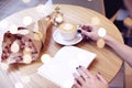 Cappuccino latte coffee in woman hand with heart on top. Flowers on wooden table in modern cafe. St. Valentines celebration concep Royalty Free Stock Photo