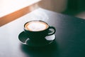 Cappuccino or latte with frothy foam,black coffee cup on dark table