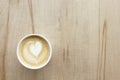 Cappuccino in paper take away cup on light wood table