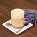 Cappuccino raf coffee with lavender in glass cup on brown table