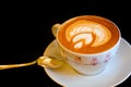 Cappuccino, silver spoon, leaf on a foam