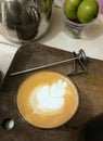 Cappucino coffee with tulip latteart style which put on brown wood