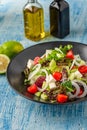 Caprese Italian or Mediterranean or Greek salad. Tomato, peynir, basil leaves and olive oil on wooden table
