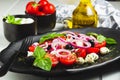 Caprese Italian or Mediterranean salad. Tomato mozzarella basil leaves black olives and olive oil on wooden table Royalty Free Stock Photo