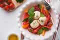 Caprese salad. Italian caprese salad with sliced tomatoes, mozzarella cheese, basil, olive oil in white plate over white backgroun Royalty Free Stock Photo