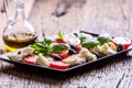 Caprese Salad.Mediterranean salad. Mozzarella cherry tomatoes basil and olive oil on old oak table. Italian cuisine