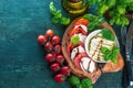 Caprese salad. Mozzarella cheese, tomatoes and basil herb leaves.