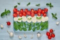 Caprese salad with organic ingredients: mozzarella cheese, cherry tomatoes, fresh basil leaves, garlic. Traditional italian food Royalty Free Stock Photo