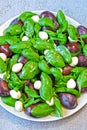 Caprese salad with plums. Fruity caprese. Healthy salad with basil and plums on a plate. A plate with a useful salad.