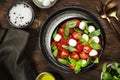 Caprese salad with ripe red tomatoes and mozzarella cheese with fresh green basil leaves. Italian food. Top view, wooden Royalty Free Stock Photo