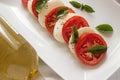 Caprese salad with ripe tomatoes and mozzarella cheese with fresh basil leaves. Italian food. Royalty Free Stock Photo