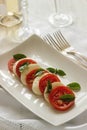 Caprese salad with ripe tomatoes and mozzarella cheese with fresh basil leaves. Italian food. Royalty Free Stock Photo