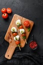 Caprese salad skewer with tomato on sticks Italian traditional caprese salad ingredients. Mediterranean food. over black stone