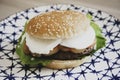 Caprese style hamburger topped with slices of fresh mozzarella cheese, tomato, basil leaves, and lettuce on toasted brioche bun on Royalty Free Stock Photo