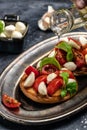 Caprese toasts with mozzarella, cherry tomatoes and fresh garden basil. Traditional italian appetizer or snack, antipasto. Royalty Free Stock Photo