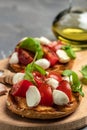 Caprese toasts with mozzarella, cherry tomatoes and fresh garden basil. Traditional italian appetizer or snack, antipasto. Royalty Free Stock Photo