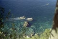 CAPRI, ITALY, 1959 - Two tourist boats returning from the Blue Grotto chase each other in the blue sea of Capri Royalty Free Stock Photo