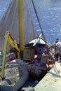 CAPRI, ITALY, 1974 - Workers unload bricks and building materials from a cargo ship on the harbor dock