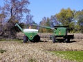 John Deere combine harvesting corn and unloading into Killbros grain wagon