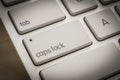 Caps lock button on white keyboard, dark filter Royalty Free Stock Photo