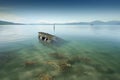 capsized boat in shallow water, sandbar visible