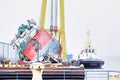 Capsized ship vessel and rescue lift crane at port dock for repair of shipwreck Royalty Free Stock Photo