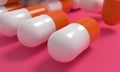 Capsule medicine pills, health pharmacy concept. Drugs for treatment medication. Heap of orange white color capsules on pink backg Royalty Free Stock Photo