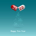 2022 capsule and powder in the shape of a Christmas tree on a blue background. Royalty Free Stock Photo