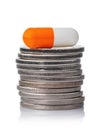 Capsule on a stack of coins isolated Royalty Free Stock Photo