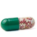 A capsule tablet on a macro shot is isolated on a white background. Dosed dosage form consisting of a soft gelatin shell