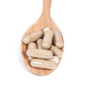 Capsules of herbs on spoon. eating for healthy