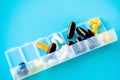 Capsules lie in a pill box on a blue background. Box for packing tablets for a week Royalty Free Stock Photo