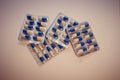 Capsules medication in white and blue packaging. 10