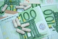 Capsules and medicines on euro banknotes. Rising prices of healthcare system. Increased costs for coronavirus pandemic.