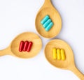 Capsules of Thai herbs medicine in the wooden spoon on white background, healthcare concept.