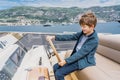 Captain boy drives the yacht. Travel adventure concept. Yachting with child on summer vacation.