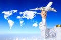 Captain holding airplane model against clouds in shape of world map concept for travel around the world Royalty Free Stock Photo