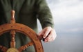 Captain holding hand on ship rudder. Royalty Free Stock Photo