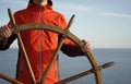 Man holding ship rudder with sea on background Royalty Free Stock Photo