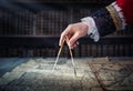 The captain of the old ship paves the course with the help of vintage maps and nautical divider. Old discovery, explorer, history Royalty Free Stock Photo