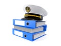 Captain`s hat on stack of ring binders