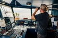 Captain of vessel or ship. He is looking through binoculars Royalty Free Stock Photo