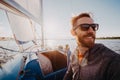 Captain of the yacht wearing sunglasses in a race on a river or sea at sunset