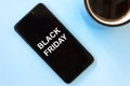 Caption BLACK FRIDAY on smartphone screen. Concept of sales, online shopping, and e-commerce.