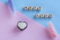 Caption with love next to flowers and heart shaped dark and white chocolate candy in dark and white chocolate. Pink and blue