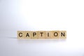 CAPTION - word of wooden blocks with a letter on white background