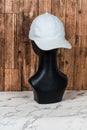 Captivate with simplicity as a white blank hat adorns a fashion head doll in this captivating mockup image